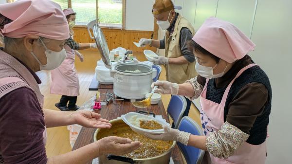 食改さんがカレーを盛り付けている画像