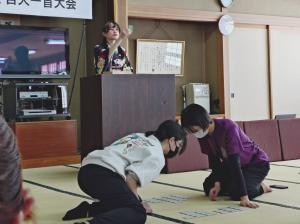 かるたを読みあげる読み手と競技者